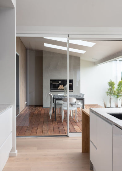 Duco Ceiling to floor sliding doors and bifold windows opening onto a deck in a house setting