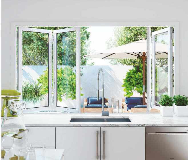 Duco bifold windows opening from the kitchen into the garden with a white finish