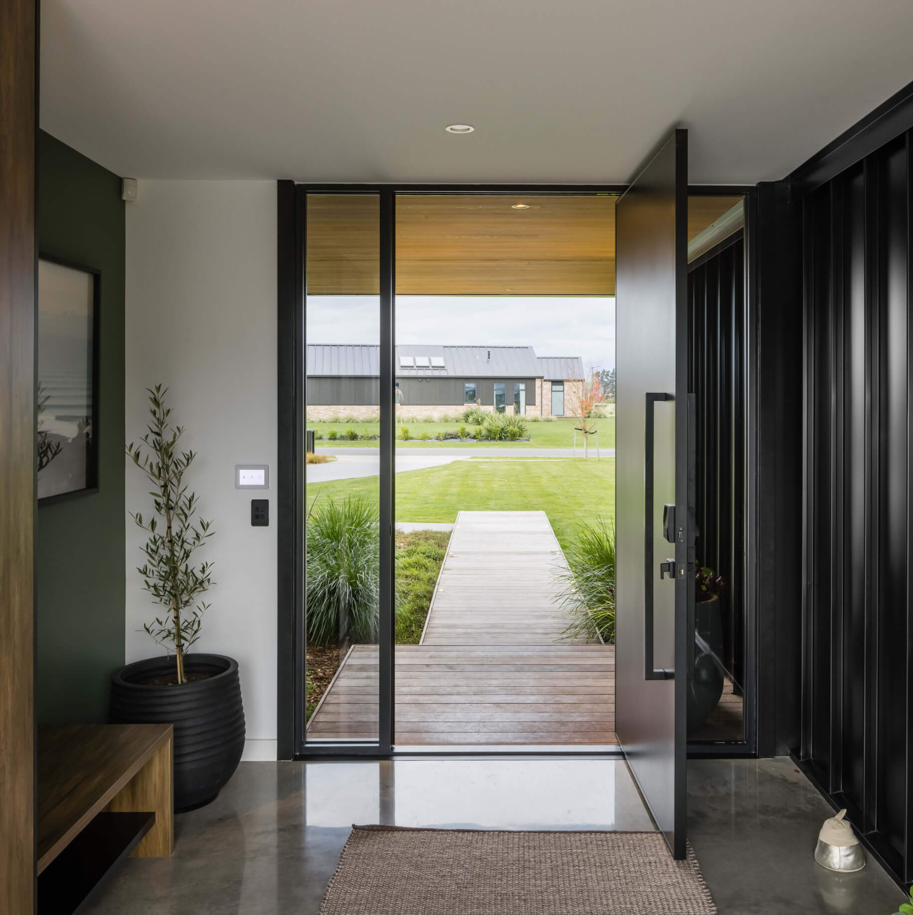 Duco entry door black with glass sides either side of the door displayed in a house
