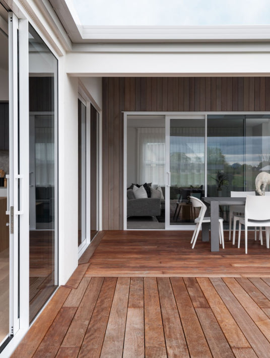 Duco Ceiling to floor sliding doors opening onto a deck in a house setting