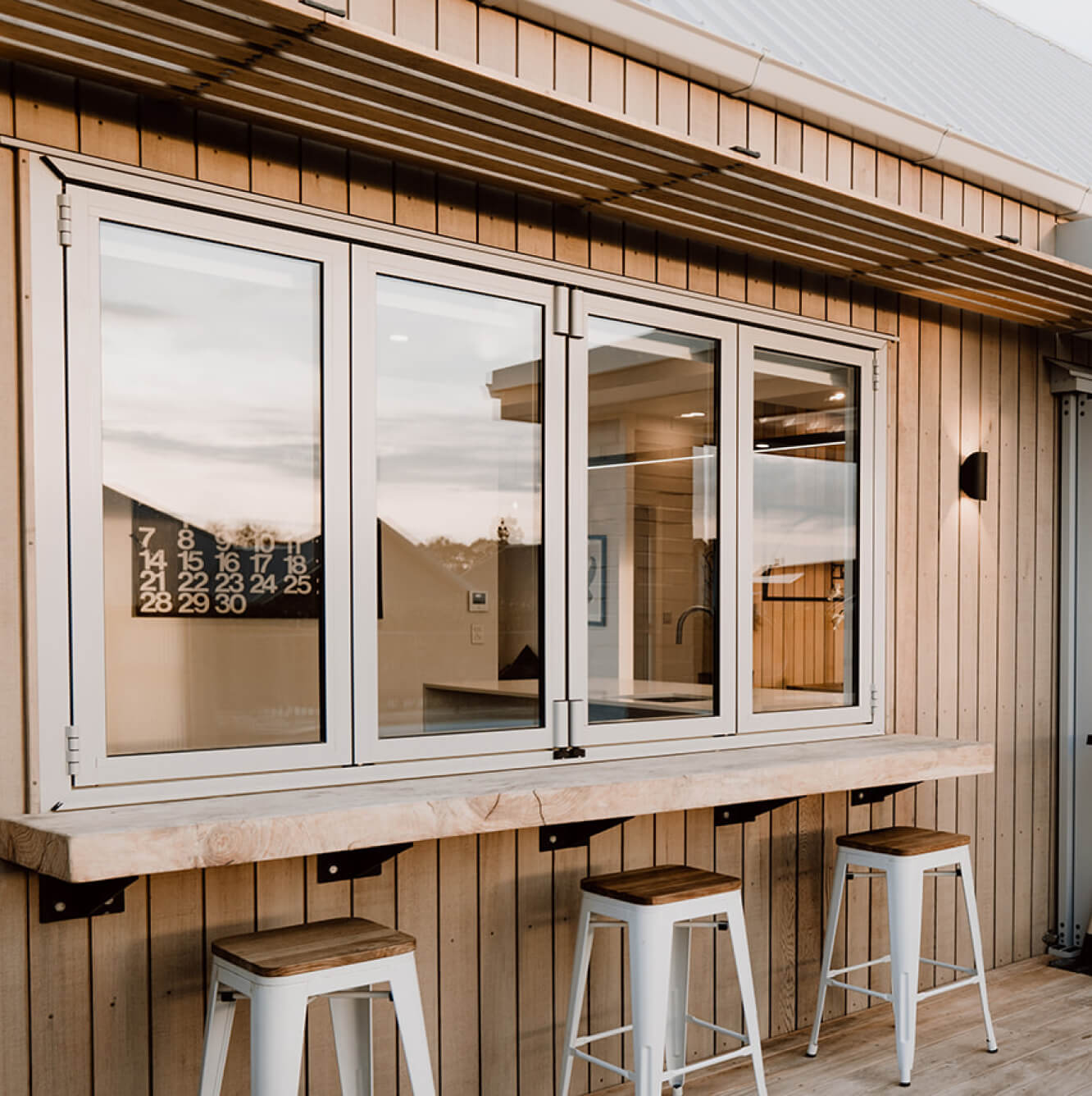 Duco bifold windows opening from the kitchen into the garden with a white finish