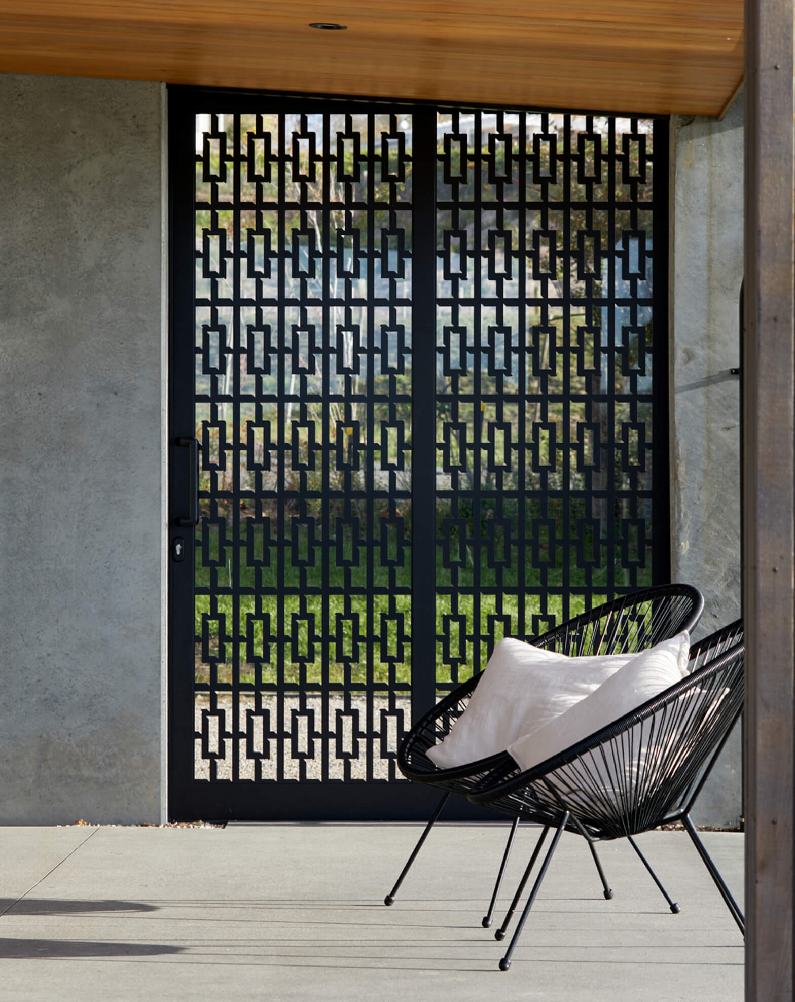 Duco image of two chairs in front a patterned door