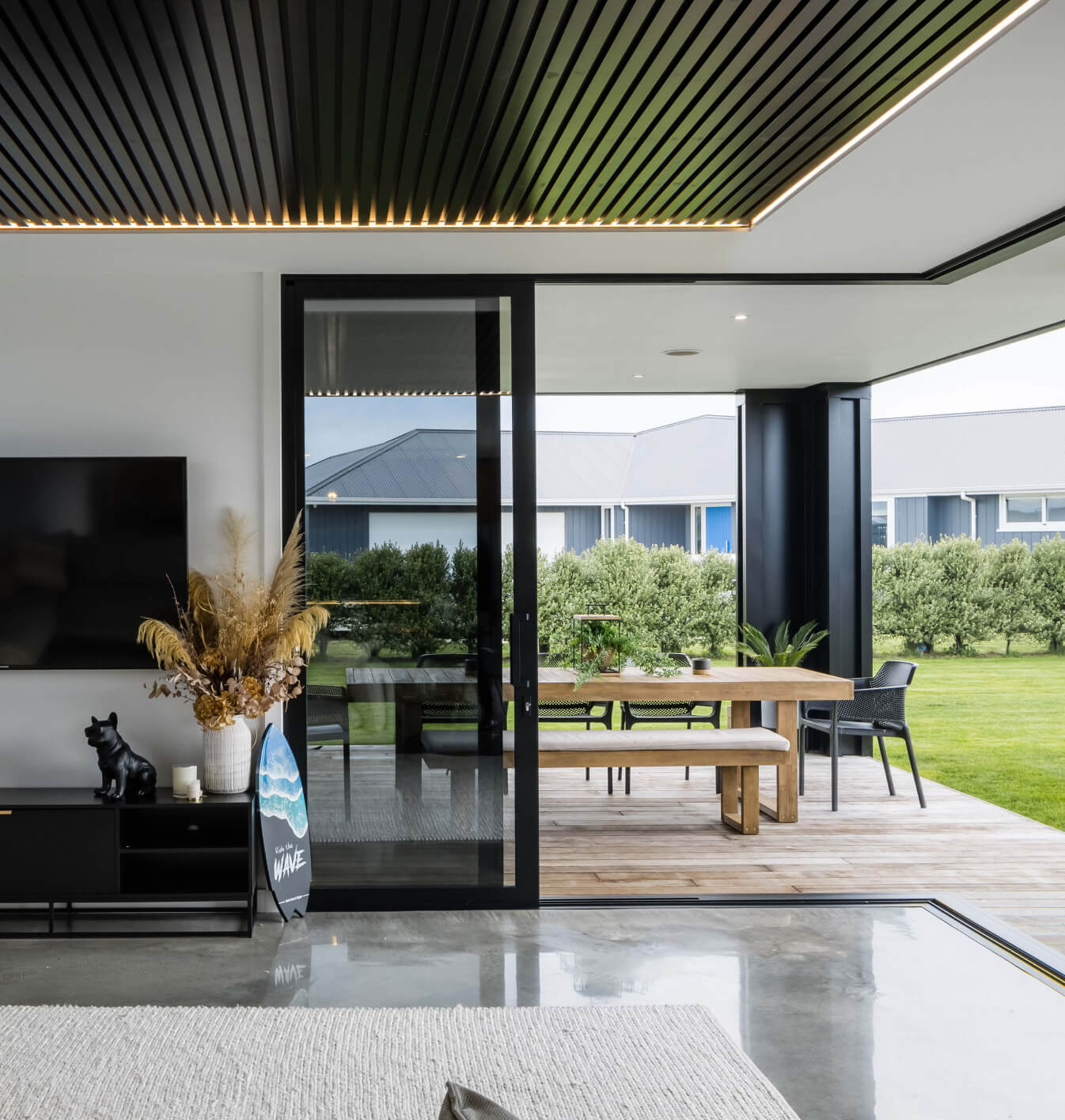 Duco Ceiling to floor sliding doors and opening onto a deck in a house setting