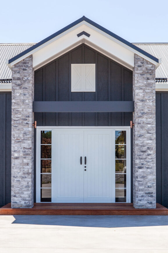 Duco entry door white double opening with glass sides framed into 5 panels either side of the door displayed in a house